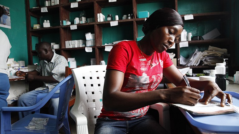 Image of a man and a woman working at desks in a healthcare office. 