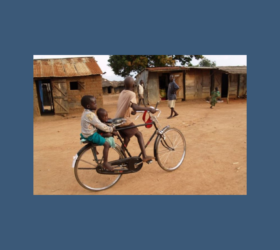 Photo of three children on a bicycle in Uganda.