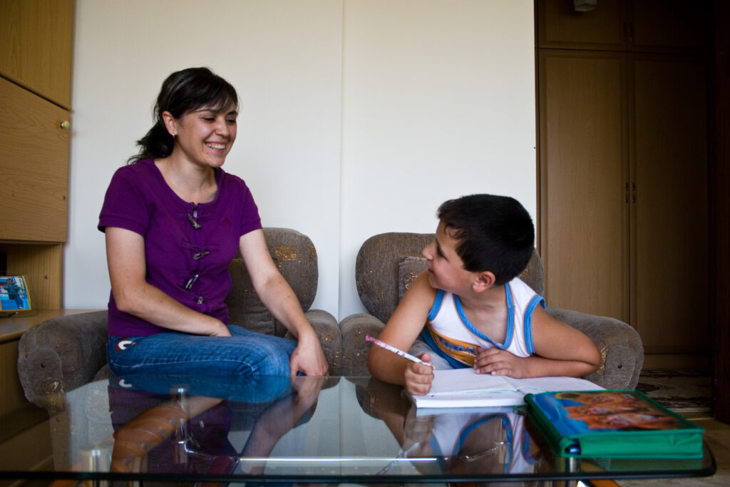 Nelly Sargsyan helps her son with his homework in their home in Armenia.