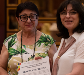 Photo of D4I’s Armenia-based M&E expert presenting a certificate recognizing participation in M&E module development to a staff member.