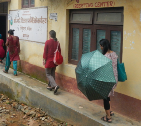 Photo of four women walking toward a small birthing center in Nepal.