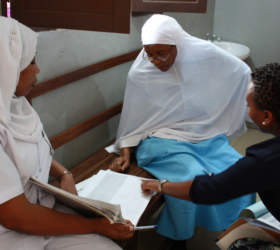 Women check on recordkeeping for insecticide-treated nets in Tanzania.
